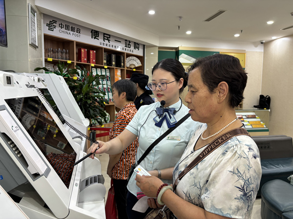 在重庆市潼南区中国邮政储蓄银行巴渝大道营业所,银行工作人员辅导市民通过ITM机自助完成城乡居民养老保险缴费。重庆市税务局供图